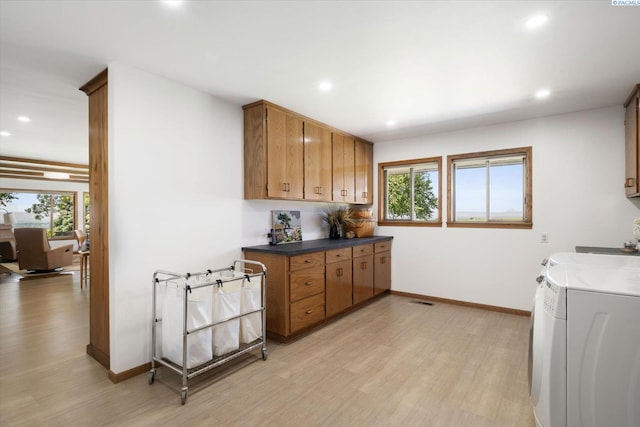 170732 Olsen Rd, Grandview, WA 98930 - kitchen with light wood-type flooring, plenty of natural light, washing machine and clothes dryer, dark countertops, and recessed lighting
