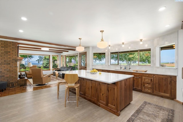 170732 Olsen Rd, Grandview, WA 98930 - kitchen featuring light countertops, brown cabinets, a center island, light wood-style floors, and hanging light fixtures