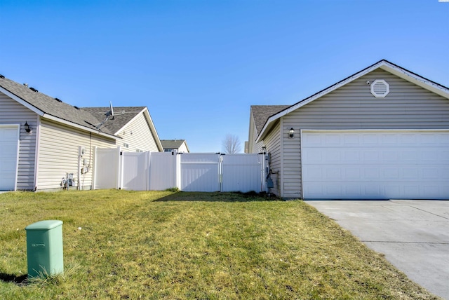 view of side of property with a garage, driveway, a lawn, a gate, and fence