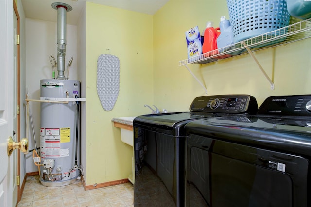 laundry room featuring laundry area, gas water heater, washing machine and clothes dryer, and baseboards