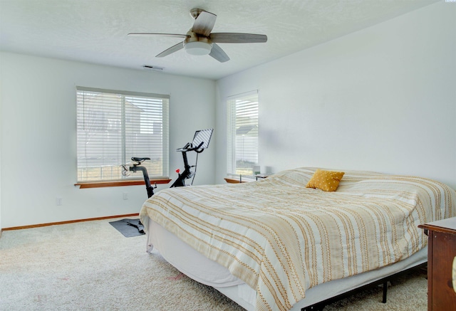 carpeted bedroom with visible vents, ceiling fan, a textured ceiling, and baseboards