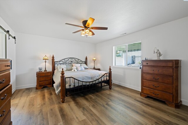 600 Lizzy Ln, Grandview, WA 98930 - bedroom with wood finished floors, baseboards, visible vents, and a barn door