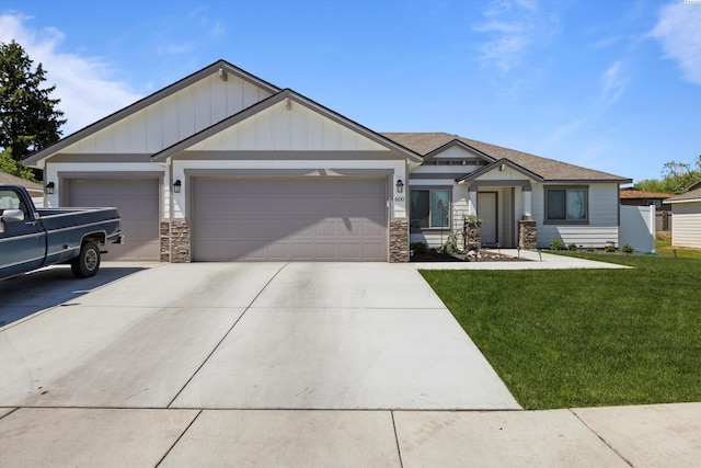 600 Lizzy Ln, Grandview, WA 98930 - craftsman-style home featuring board and batten siding, stone siding, a front lawn, an attached garage, and driveway