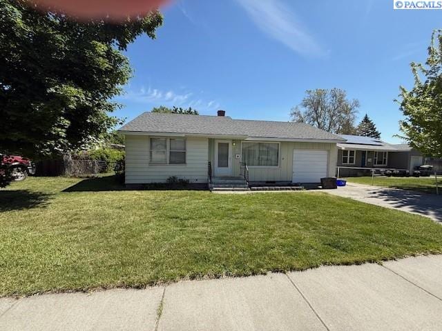view of front of house with an attached garage, driveway, fence, and a front yard