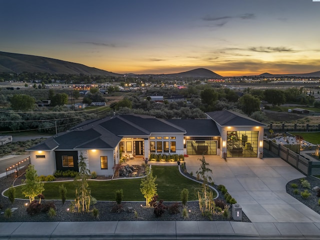 975 Rieve Ct, Richland, WA 99352 - back of property at dusk with a mountain view, an attached garage, and driveway