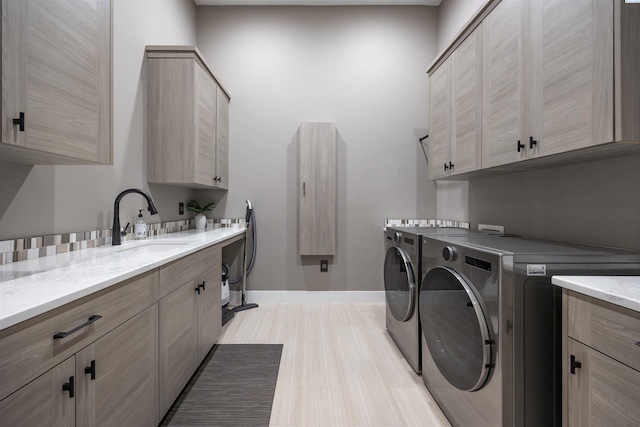 975 Rieve Ct, Richland, WA 99352 - washroom with washing machine and dryer, cabinet space, and light wood-type flooring