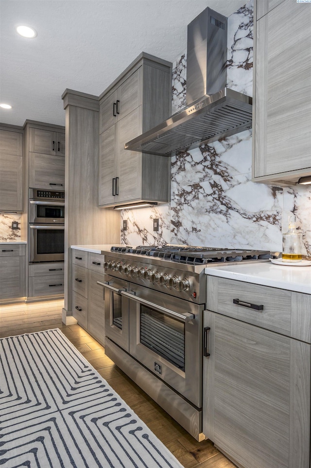 975 Rieve Ct, Richland, WA 99352 - kitchen featuring wall chimney exhaust hood, stainless steel appliances, backsplash, gray cabinetry, and recessed lighting