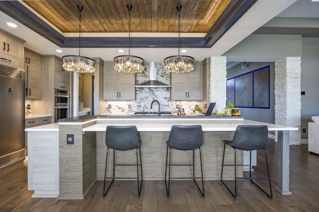 975 Rieve Ct, Richland, WA 99352 - kitchen featuring wall chimney exhaust hood, a tray ceiling, stainless steel appliances, a chandelier, and wood ceiling