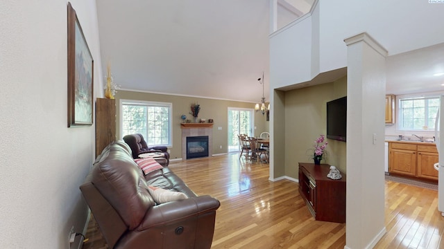 470 NW Robert St, Pullman, WA 99163 - living area featuring light wood finished floors, a fireplace, a chandelier, and a towering ceiling