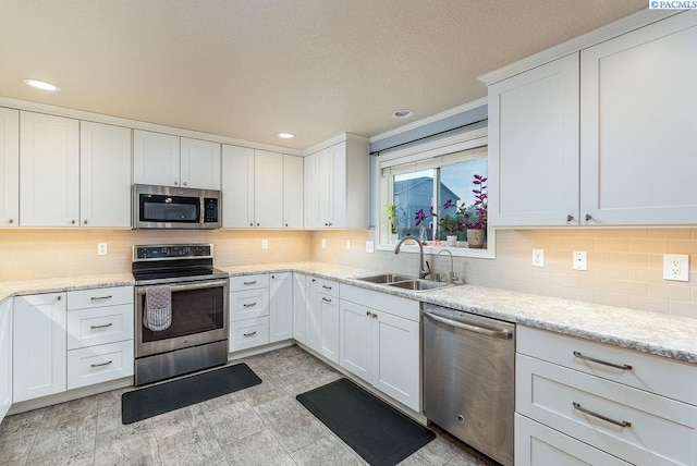 5309 Buchanan Ln, Pasco, WA 99301 - kitchen with stainless steel appliances, a sink, white cabinets, decorative backsplash, and recessed lighting