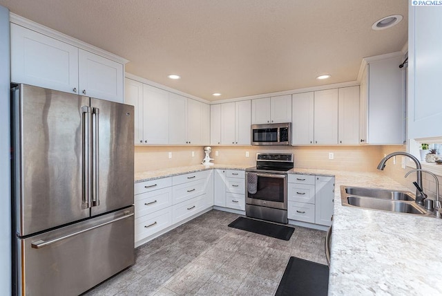 5309 Buchanan Ln, Pasco, WA 99301 - kitchen with stainless steel appliances, a sink, white cabinets, decorative backsplash, and recessed lighting