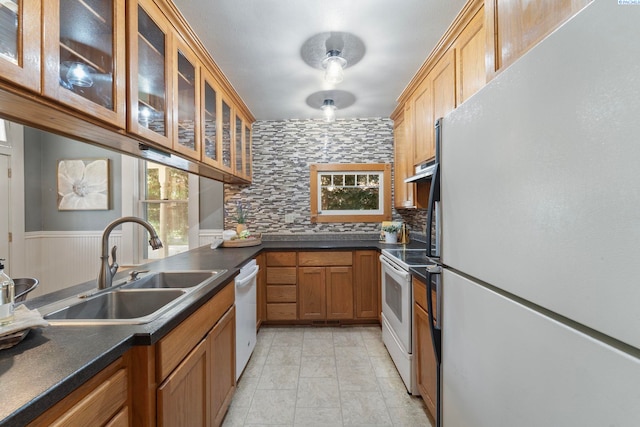 1002 Sherman Ave, Prosser, WA 99350 - kitchen featuring white appliances, decorative backsplash, dark countertops, and a wainscoted wall