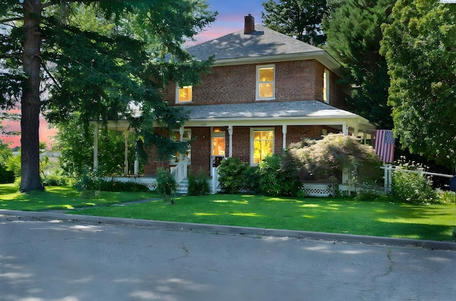 1002 Sherman Ave, Prosser, WA 99350 - american foursquare style home with brick siding, covered porch, a chimney, and a front lawn