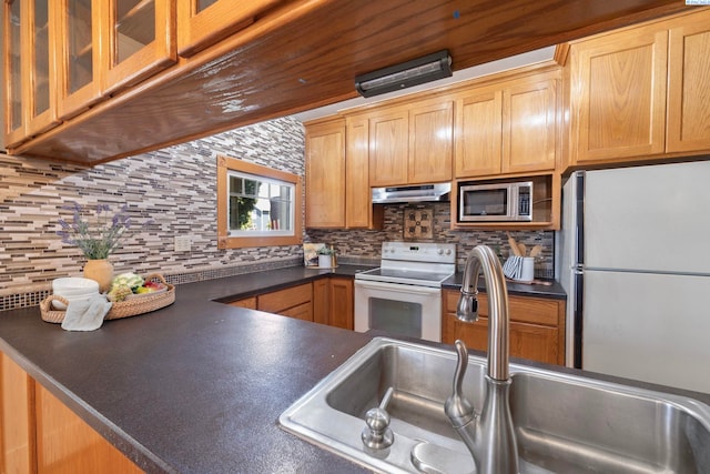1002 Sherman Ave, Prosser, WA 99350 - kitchen featuring white range with electric cooktop, freestanding refrigerator, stainless steel microwave, under cabinet range hood, and dark countertops