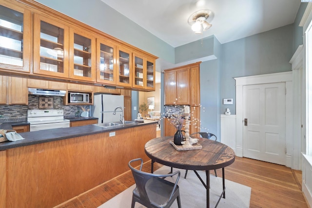 1002 Sherman Ave, Prosser, WA 99350 - kitchen with white appliances, under cabinet range hood, decorative backsplash, and dark countertops