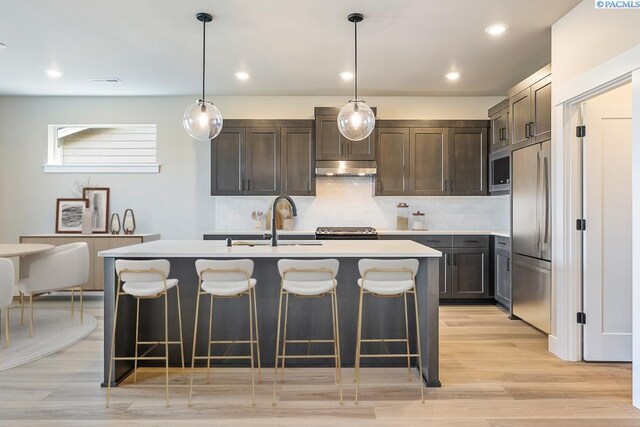 2864 Avrio Ave, Richland, WA 99354 - kitchen featuring built in appliances, a sink, under cabinet range hood, light countertops, and recessed lighting
