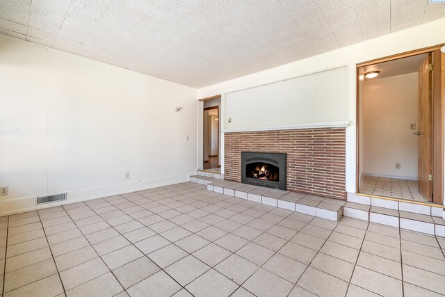 2214 W Clearwater Ave, Kennewick, WA 99336 - unfurnished living room with light tile patterned flooring and a tiled fireplace