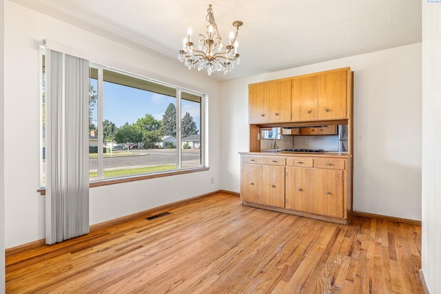2214 W Clearwater Ave, Kennewick, WA 99336 - kitchen with a chandelier, light wood finished floors, baseboards, and decorative light fixtures