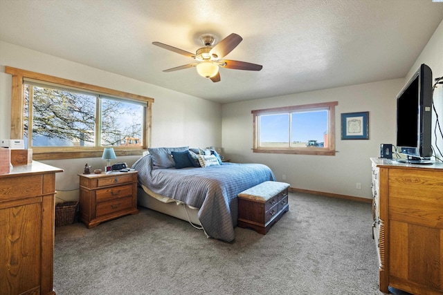 bedroom featuring light colored carpet, a textured ceiling, baseboards, and ceiling fan