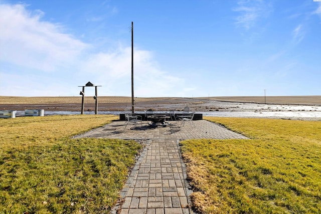 view of yard with a water view, a fire pit, and a patio