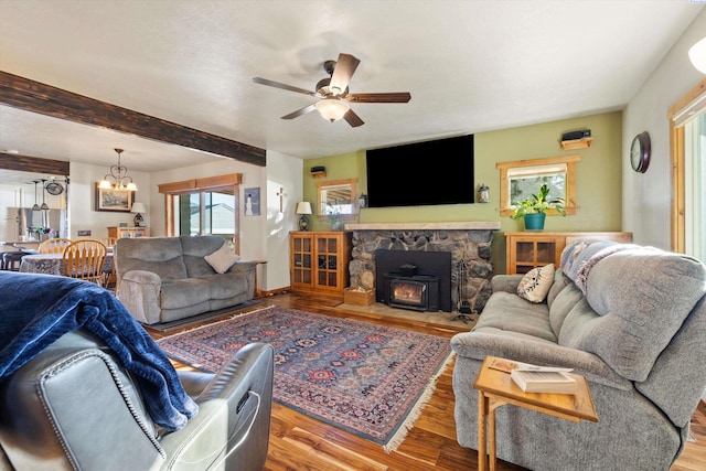 living area featuring ceiling fan with notable chandelier, beamed ceiling, and wood finished floors