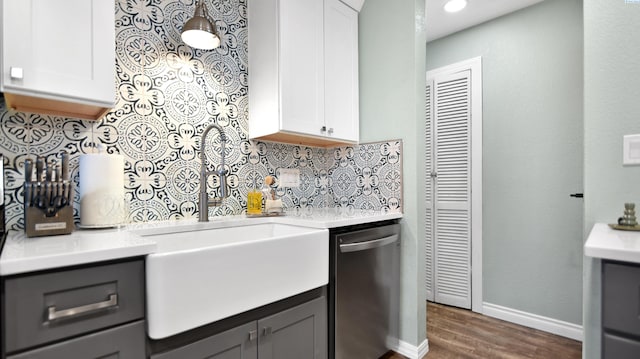 kitchen with dishwasher, light countertops, white cabinetry, and decorative backsplash