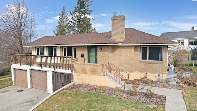 single story home with brick siding, a shingled roof, concrete driveway, a trampoline, and a chimney