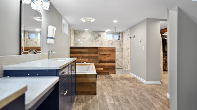 full bath featuring a walk in shower, wood finished floors, vanity, a bath, and a walk in closet