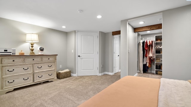 bedroom with light carpet, baseboards, a walk in closet, a closet, and recessed lighting