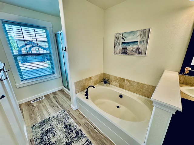 4516 NW Commons Dr, Pasco, WA 99301 - full bathroom featuring a garden tub, wood finished floors, a stall shower, and vanity