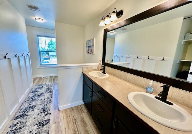 4516 NW Commons Dr, Pasco, WA 99301 - bathroom featuring wood finished floors, double vanity, and decorative backsplash