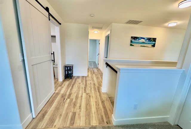 4516 NW Commons Dr, Pasco, WA 99301 - corridor with a barn door and light wood-style floors