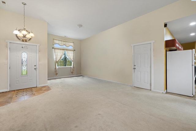 entrance foyer with light carpet and a chandelier