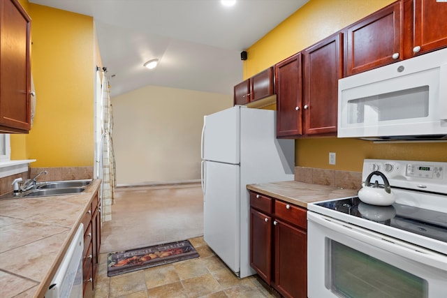 kitchen featuring vaulted ceiling, white appliances, tile countertops, and sink