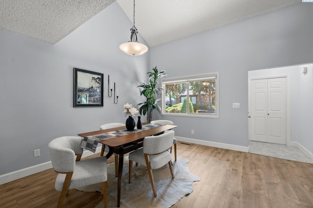 4214 W Klamath Ave Unit B-2, Kennewick, WA 99336 - dining space with baseboards, light wood-style flooring, high vaulted ceiling, and a textured ceiling