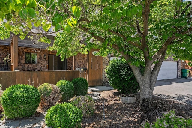 4214 W Klamath Ave Unit B-2, Kennewick, WA 99336 - view of property hidden behind natural elements featuring stone siding, a garage, and asphalt driveway