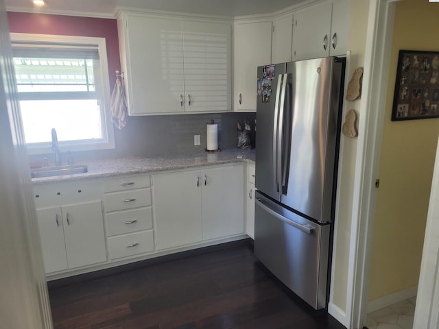 907 Cedar Ave, Richland, WA 99352 - kitchen featuring freestanding refrigerator, a sink, white cabinetry, and decorative backsplash