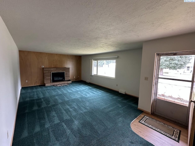404 D St, Endicott, WA 99125 - unfurnished living room featuring a textured ceiling, carpet floors, and a brick fireplace