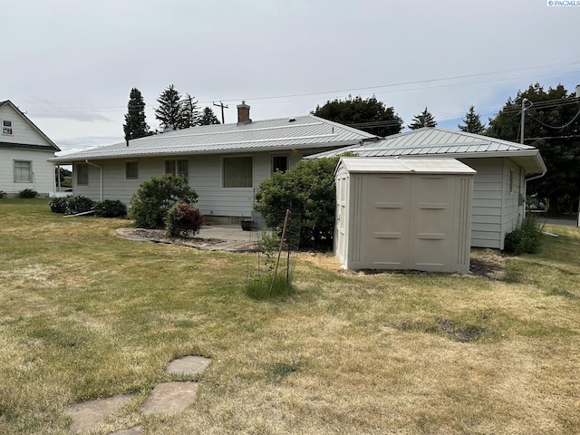 404 D St, Endicott, WA 99125 - rear view of house with a storage shed, a yard, a metal roof, and a chimney