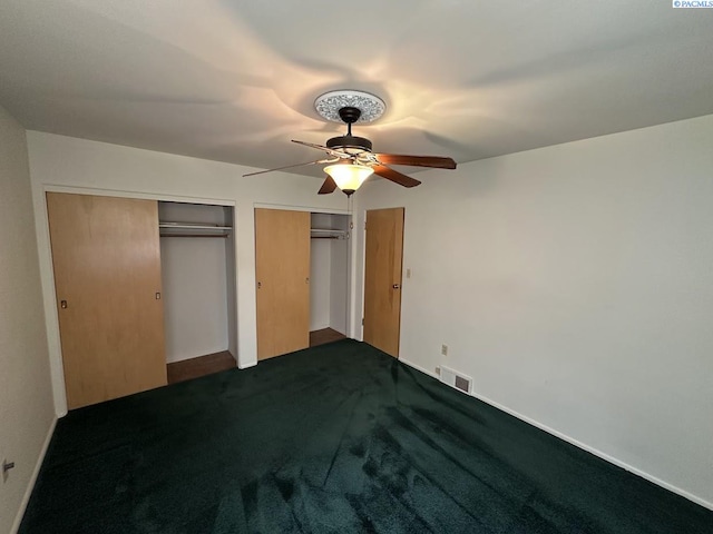 404 D St, Endicott, WA 99125 - unfurnished bedroom featuring dark carpet, a ceiling fan, and two closets