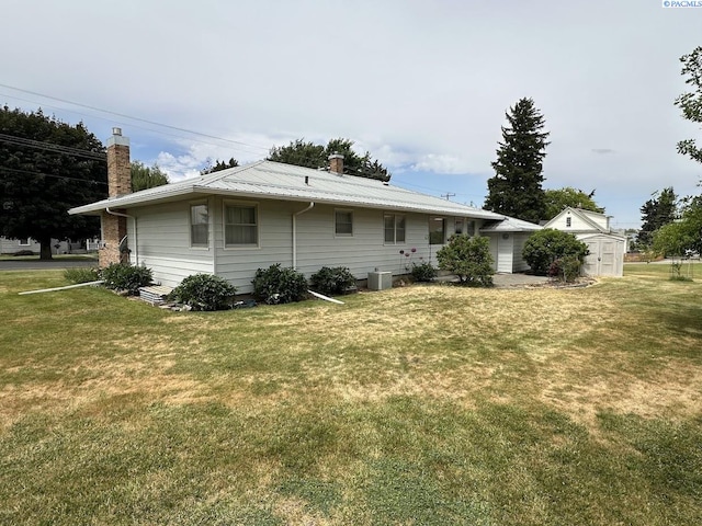 404 D St, Endicott, WA 99125 - back of property with a chimney, a lawn, a metal roof, and a storage shed