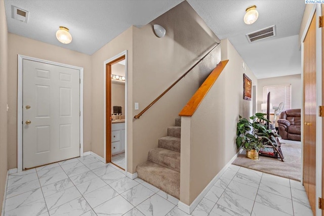 5001 E Killdeer Ct, West Richland, WA 99353 - entryway featuring light marble finish flooring, baseboards, stairs, and a textured ceiling