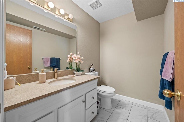 5001 E Killdeer Ct, West Richland, WA 99353 - bathroom featuring vanity, marble finish flooring, toilet, and baseboards