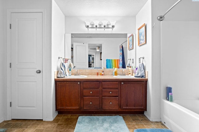 bathroom with vanity, ceiling fan, a textured ceiling, and shower / bathing tub combination