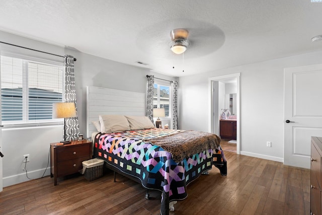 bedroom featuring ceiling fan, hardwood / wood-style flooring, ensuite bath, and a textured ceiling