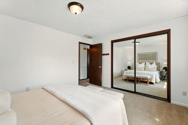 bedroom featuring a textured ceiling, a closet, baseboards, and carpet floors