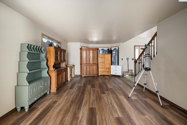 living room featuring stairs, baseboards, and dark wood finished floors