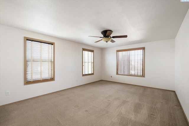 spare room featuring carpet flooring, a ceiling fan, and baseboards