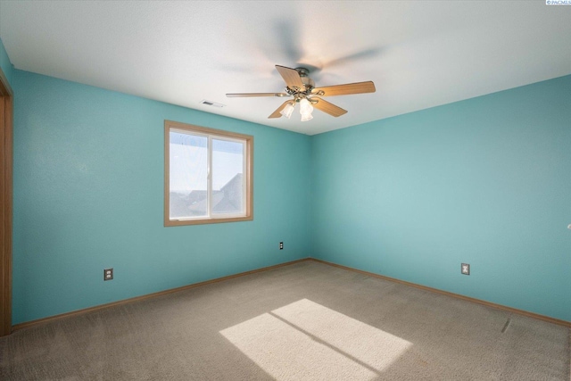 spare room with carpet, visible vents, ceiling fan, and baseboards