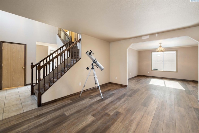 interior space with stairs, a textured ceiling, and wood finished floors